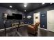 Basement exercise room with dark walls and a wall-mounted television at 1661 Hammock Dr, Smyrna, GA 30080