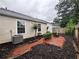 Cozy backyard with a small brick patio area surrounded by fresh mulch and green shrubs for outdoor relaxation at 1822 Commonwealth Dr, Woodstock, GA 30188