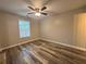 Neutrally painted bedroom with ceiling fan, natural light, and modern vinyl flooring at 1822 Commonwealth Dr, Woodstock, GA 30188