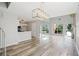 Open-concept living space featuring modern light fixtures, fireplace, and seamless flow to other areas at 1822 Commonwealth Dr, Woodstock, GA 30188