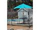 Community swimming pool and lounge area with shade umbrella, table and chairs, surrounded by a wrought iron fence at 1822 Commonwealth Dr, Woodstock, GA 30188