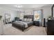Spacious bedroom featuring neutral carpet, a large bed, sitting chair, and stylish decor at 2127 Apple Orchard Way, Austell, GA 30168