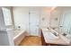 Bathroom featuring double sinks, soaking tub and white cabinets at 4676 Shaded Oak Ln, Forest Park, GA 30297