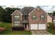 Charming brick two-story home with a two-car garage and well-maintained front lawn at 4676 Shaded Oak Ln, Forest Park, GA 30297