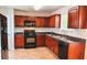 Functional kitchen featuring wood cabinets, black appliances, and tile floors at 4676 Shaded Oak Ln, Forest Park, GA 30297