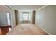 Bright living room featuring neutral walls, carpet floors, and a bay window at 4676 Shaded Oak Ln, Forest Park, GA 30297