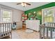 Bright Bedroom features two cribs, green accent wall, and light wood flooring at 118 Greenwood St, Fairburn, GA 30213