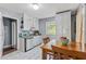 Eat-in kitchen featuring white cabinets and appliances, and wooden furniture at 118 Greenwood St, Fairburn, GA 30213