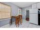 Bright eat-in kitchen with white appliances, and a view of the adjacent room at 118 Greenwood St, Fairburn, GA 30213