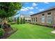 Expansive backyard with lush green lawn, landscaped flower beds, and a view of an outdoor patio area at 2115 Creekstone Point Dr, Cumming, GA 30041