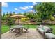 Landscaped backyard with an umbrella, patio, table and chairs and a green outdoor sofa at 2115 Creekstone Point Dr, Cumming, GA 30041