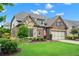 Beautifully landscaped single-Gathering home exterior with stone and brick facade at 2115 Creekstone Point Dr, Cumming, GA 30041