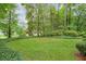Lush backyard featuring a well-maintained lawn, mature trees, and privacy landscaping at 3564 Liberty Ln, Marietta, GA 30062