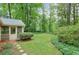 A serene backyard with a screened porch, lush greenery, and a well-maintained lawn at 3564 Liberty Ln, Marietta, GA 30062