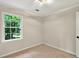 This is a bedroom with neutral walls, beige carpeting, and a window that overlooks the backyard at 3564 Liberty Ln, Marietta, GA 30062