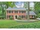 Charming two-story brick home featuring a well-manicured lawn and mature trees at 3564 Liberty Ln, Marietta, GA 30062