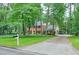 Charming brick home with a lush front yard, mature trees, and a long driveway leading to a two-car garage at 3564 Liberty Ln, Marietta, GA 30062