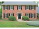 Classic brick home with black shutters and a well-manicured front lawn featuring mature trees and shrubs at 3564 Liberty Ln, Marietta, GA 30062