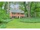 This lovely brick home features black shutters, lush landscaping, and mature trees offering privacy and curb appeal at 3564 Liberty Ln, Marietta, GA 30062