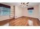 Empty bedroom with hardwood floors, two windows, and built-in shelving at 421 Fond Du Lac Dr, Stone Mountain, GA 30088