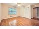 A sunlit bedroom showcasing hardwood floors, a window, and a closet with folding doors at 421 Fond Du Lac Dr, Stone Mountain, GA 30088