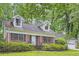 Charming brick home with dormer windows, black shutters, and lush landscaping at 421 Fond Du Lac Dr, Stone Mountain, GA 30088