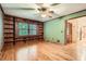 A quaint living room featuring hardwood floors, a large window, and built-in shelving at 421 Fond Du Lac Dr, Stone Mountain, GA 30088