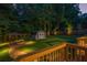 Backyard with a fire pit, deck, shed and thoughtful landscape lighting for evening enjoyment at 5761 E Emerald Oaks Ln, Acworth, GA 30102