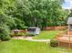 Well-kept backyard features a fire pit, shed, wooden fence, and lush landscaping at 5761 E Emerald Oaks Ln, Acworth, GA 30102
