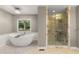 Bathroom boasting a modern soaking tub, glass shower, and serene views from the window at 5761 E Emerald Oaks Ln, Acworth, GA 30102