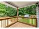 Covered deck overlooking landscaped backyard with lush greenery and charming outbuilding at 5761 E Emerald Oaks Ln, Acworth, GA 30102