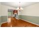 Inviting dining area showcasing wainscoting, hardwood floors, and access to the living room with fireplace at 5761 E Emerald Oaks Ln, Acworth, GA 30102