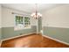 Cozy dining room with wood floors, stylish lighting, and beautiful natural light from large window at 5761 E Emerald Oaks Ln, Acworth, GA 30102