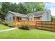 Back exterior view of home with a large deck, well-manicured lawn, and fenced yard at 5761 E Emerald Oaks Ln, Acworth, GA 30102