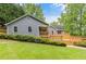 Back exterior of home with an expansive wooden deck and well-maintained lawn at 5761 E Emerald Oaks Ln, Acworth, GA 30102