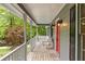 Charming front porch with wicker seating and views of the landscaped front yard and colorful trees at 5761 E Emerald Oaks Ln, Acworth, GA 30102