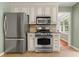Efficient kitchen with stainless steel appliances, granite counters, tile flooring, and green painted walls at 5761 E Emerald Oaks Ln, Acworth, GA 30102