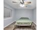 Bedroom with a ceiling fan, window with blinds, hardwood floors, and a bed with a green cover at 7307 Cardigan Cir, Sandy Springs, GA 30328