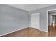 Bedroom with wood flooring, neutral walls, and white closet doors at 7307 Cardigan Cir, Sandy Springs, GA 30328
