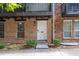 Charming brick townhome entrance with a white door, complemented by neat landscaping and clear address number at 7307 Cardigan Cir, Sandy Springs, GA 30328