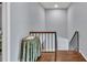 Upstairs hallway with wood floors, black railings, and a round side table with a floral cover at 7307 Cardigan Cir, Sandy Springs, GA 30328