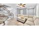 Spacious living room with an oversized sofa, staircase, and modern ceiling fan at 7307 Cardigan Cir, Sandy Springs, GA 30328