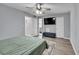 The main bedroom offers a ceiling fan, TV, and a dark blue bench at the foot of the bed at 7307 Cardigan Cir, Sandy Springs, GA 30328