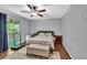 A spacious main bedroom with hardwood floors, ceiling fan, sliding glass door and stylish rug at 7307 Cardigan Cir, Sandy Springs, GA 30328