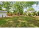 Large backyard with a shed, green lawn, mature trees, and a wooden fence, perfect for outdoor activities at 80 Vinson Se Dr, Atlanta, GA 30317