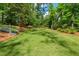 Spacious backyard with mature trees, landscaping, slide, and play area, perfect for Gathering enjoyment at 302 Chinquapin Sw Dr, Marietta, GA 30064