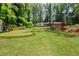 Backyard featuring putting green, mature trees and well-maintained lawn at 302 Chinquapin Sw Dr, Marietta, GA 30064