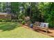 Serene backyard with a charming bench, manicured landscaping, mature trees and play area at 302 Chinquapin Sw Dr, Marietta, GA 30064
