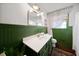 Green bathroom with vintage-style decor, beadboard wainscoting, and white countertop at 302 Chinquapin Sw Dr, Marietta, GA 30064