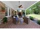 Relaxing covered patio with brick floor, ceiling fan, brick fireplace, and comfortable seating with views of the yard at 302 Chinquapin Sw Dr, Marietta, GA 30064